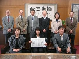 表彰状を受け取り，笑顔を見せる小林さん(前列中央)