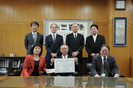 表彰を受けた佐藤さん(中央)と学長，理事による記念撮影