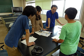 白熱電球のフィラメントの素材を変えて行う実験アドバイスを受ける岡崎市内の中学3年生