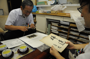 市川さん直筆のはがきなどを見入る筆者（尾西歴史民俗資料館で）