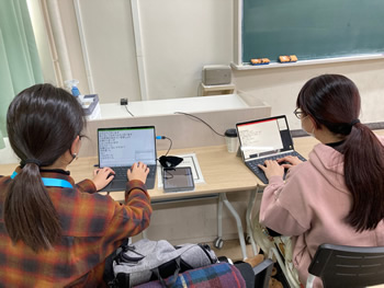 2人の学生がパソコンテイクをしています。