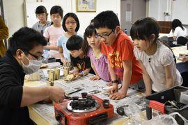 金属の流し込みを見つめる子どもたち