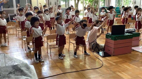 オンライン交流時にスクリーンに手を振っている園児