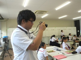 授業の様子の記録写真を撮影している場面