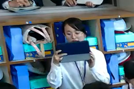 子どもたちの様子を撮影する学生ICT支援員
