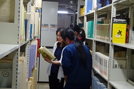 書庫で資料の説明を聞く様子