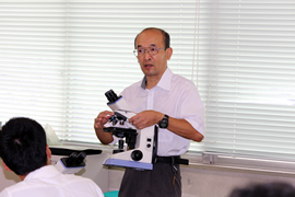 顕微鏡の取り扱いを説明する澤教員