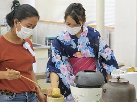 生徒の説明でお茶を点てる留学生