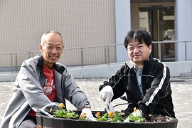 ビオラを植栽する野田学長（左）と後藤理事（右）