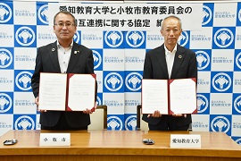 協定締結の記念写真（左：中川宣芳教育長、右：野田敦敬学長）