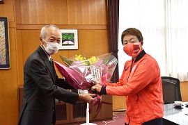 加治さんへ花束を贈る野田敦敬学長（左）