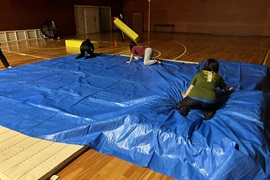 避難所内設営の準備をする学生