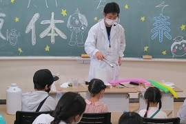 子どもたちに実験を披露する学生