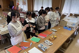 協力し合って準備をする二つの大学の学生<br>（手前5人が幼児教育専攻の学生たち）