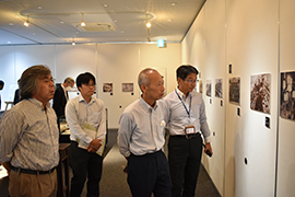 写真パネルを観覧する野田敦敬学長ら