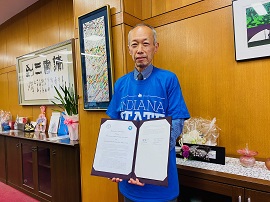 贈呈されたオリジナルTシャツを着る野田学長
