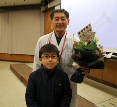花束を手に小学生と記念撮影
