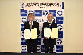 署名した覚書を手にする市野聖治会長（左）と野田敦敬学長（右）