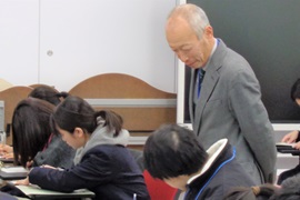 アンケートを記入する参加者を見守る野田敦敬学長