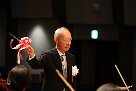 フィナーレの全体合唱で指揮をする野田敦敬学長
