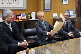 賞状を眺める野田敦敬学長