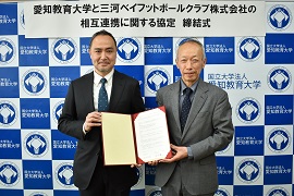 協定書を手にする佐々木代表取締役社長（左）と野田学長（右）