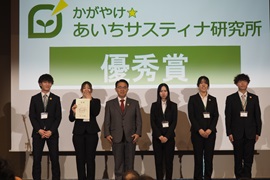 優秀賞チーム「チーム・LIXIL」のメンバーと大村知事<br>研究員の土井さん（右から2人目）