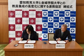 署名する金城学院大学の小室尚子学長（左）<br>本学の野田敦敬学長（右）