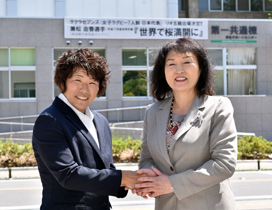 横断幕をバックに兼松選手と後藤学長