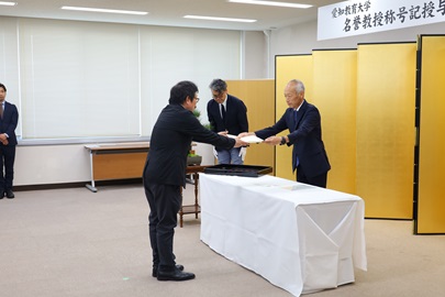 野田敦敬学長から称号記を手渡す様子