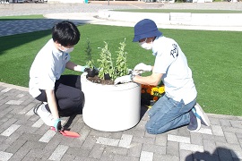 野田敦敬学長（右）と附属高校生徒（左）による植栽の様子