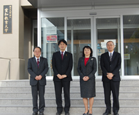 本部棟玄関前で（左から）白石理事，大西議員，後藤学長，菅沼理事